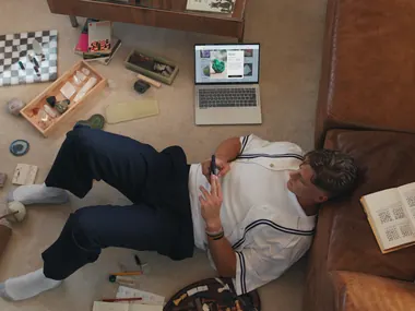 Joe Burrow lies on the floor, surrounded by his custom mineral and crystal chess set, looking at his phone