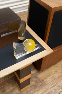 Solange Knowles' unfinished sculpture features clear glass objects and a yellow orb on a black and wood table