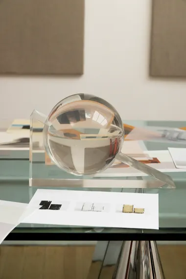 Solange Knowles's "Unfinished Sculpture" features a clear glass sphere and architectural elements on a glass table