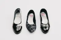 Three custom PinkPantheress ballet flats are displayed, two glossy black and one black lace